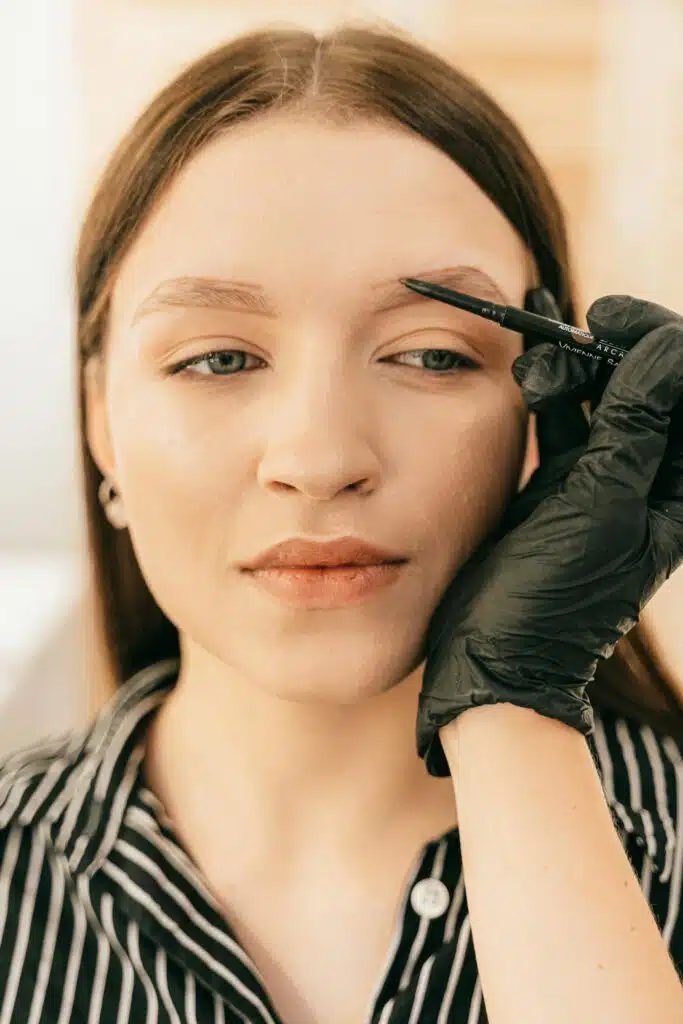 Femme en train de se faire épiler les sourcils à la pince avec précision.