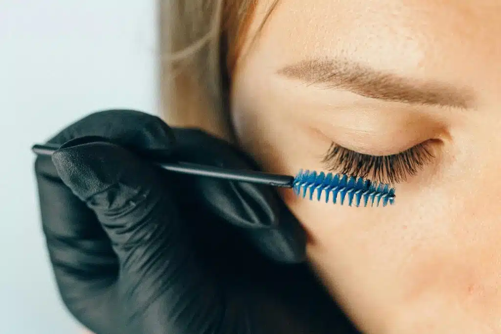 Femme en pleine teinture des sourcils par une professionnelle.